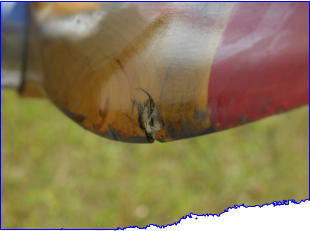 Propeller damage from exhaust spring entering prop on Beaver ultralight aircraft.