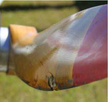 Wood propeller with damage from exhaust spring hitting it in flight.